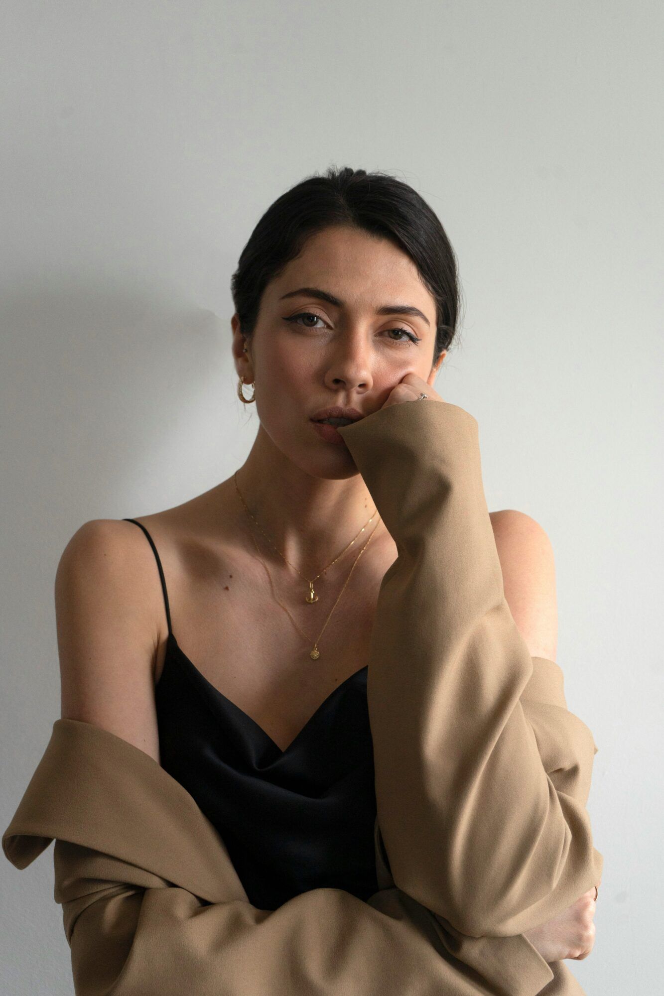 Fashion portrait of a woman in a camel coat and black slip top