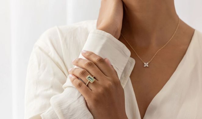 Model wearing a delicate L. Priori pendant necklace with a white linen shirt